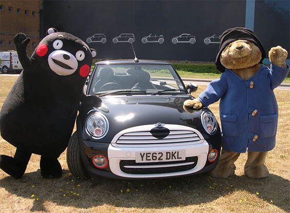 Kumamon và gấu Paddington đứng cạnh xe Kumamon Mini của BMW tại sự kiện ở Oxford, Anh quốc vào năm 2013.