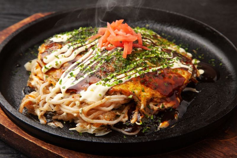 Okonomiyaki kiểu Hiroshima thường bao gồm mì xào yakisoba.