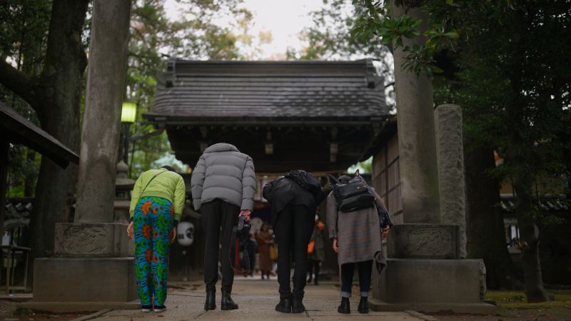 Cúi đầu trước cổng torii.